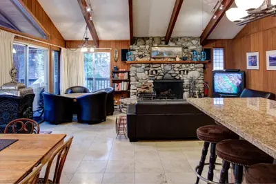 a living room with a stone fireplace and a tv at 12B Star Gazers in Wawona