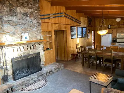 a living room with a fireplace and a dining room at 3A Cutters Edge in Wawona