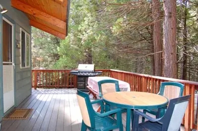 a patio with a table and chairs on a deck at 30A Dunnings Retreat in Wawona