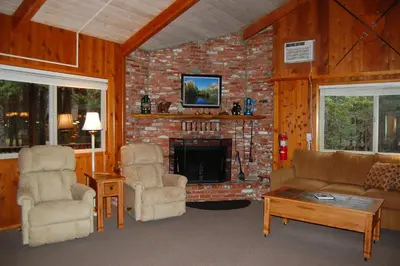 a living room with a couch and chairs and a fireplace at 30A Dunnings Retreat in Wawona