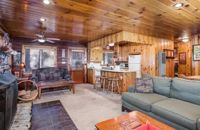 a living room with a couch and a kitchen at 70 Simmons Den in Wawona