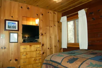 a bedroom with a bed and a television in a cabin at 73 Walk-A-Bout in Wawona