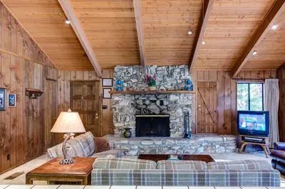 a living room with a stone fireplace and a couch at 40 Coyles Cabin in Wawona