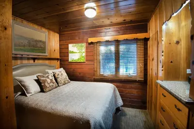 a bedroom with a bed in a wooden cabin at 48 Sugar Pine Suite in North Wawona