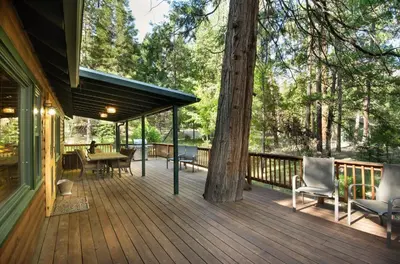 a large wooden deck with chairs and a tree at 48 Sugar Pine Suite in North Wawona