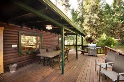 a wooden deck with a table and chairs on it at 48 Sugar Pine Suite in North Wawona