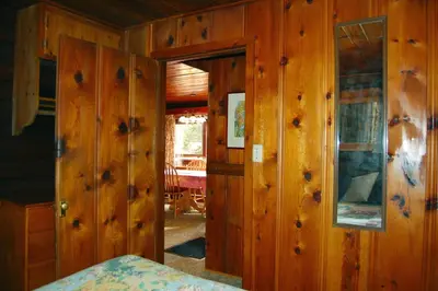 a room with wooden walls and a door to a room at 8 Nugents Nest in North Wawona