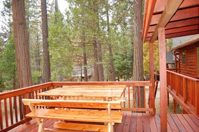 a wooden deck with benches on a cabin at 8 Nugents Nest in North Wawona
