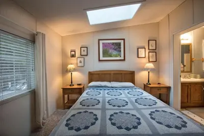 a bedroom with a large bed and a skylight at 42R Rosenberg's Creekside Cabin in Wawona