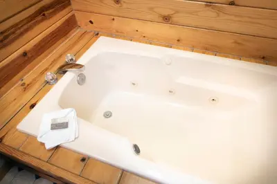 a white bath tub in a room with wooden floors at 24 Wawona Cabin in Wawona