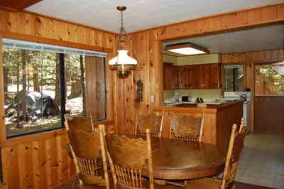 a dining room with a table and a kitchen at 9S Pine Cabin in South Wawona