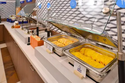 a buffet line with trays of food on display at Holiday Inn Express Rocklin - Galleria Area by IHG in Rocklin