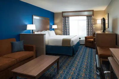 a hotel room with a large bed and a couch at Holiday Inn Express Rocklin - Galleria Area by IHG in Rocklin