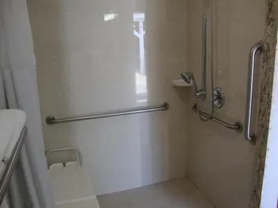 a shower in a bathroom with a glass door at Oasis Inn Sacramento- Elk Grove in Sacramento
