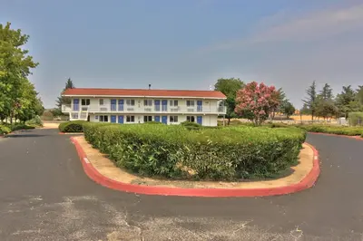 a large white house with a road in front of it at Motel 6-Sacramento, CA - North in Sacramento