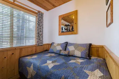 a bedroom with a bed and a mirror at Fireside Lodge in South Lake Tahoe