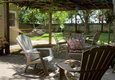 a group of chairs and a hammock in a yard at Cottage on Armstrong in Lodi