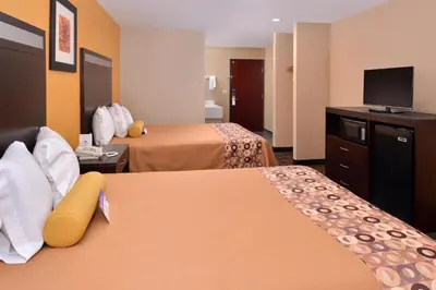 a hotel room with two beds and a flat screen tv at Americas Best Value Inn & Suites Madera in Madera