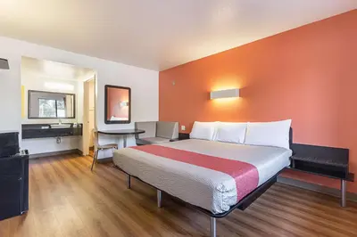 a hotel room with a large bed and a desk at Motel 6-Fresno, CA in Fresno