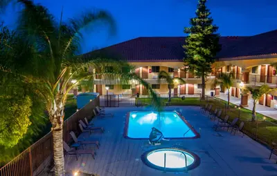a swimming pool at night with a resort at Motel 6-Santa Nella, CA - Los Banos in Santa Nella Village
