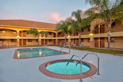 a hotel with a swimming pool in front of a building at Motel 6-Santa Nella, CA - Los Banos in Santa Nella Village