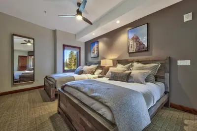 a bedroom with two beds and a mirror at Zalanta, A Vail Resorts Property in South Lake Tahoe