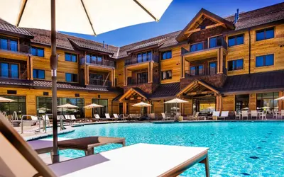 a hotel pool with tables and chairs and umbrellas at Zalanta, A Vail Resorts Property in South Lake Tahoe