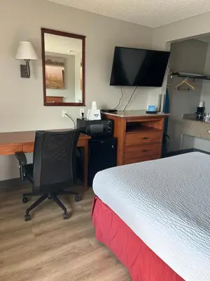 a hotel room with a bed and a desk with a computer at Days Inn by Wyndham Turlock in Turlock