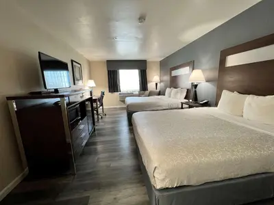 a hotel room with two beds and a flat screen tv at Best Western Americana in Dinuba