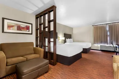 a hotel room with a bed and a chair at Comfort Suites Clovis - Fresno in Clovis