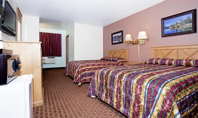 a hotel room with two beds and a flat screen tv at National 9 Inn - Placerville in Placerville