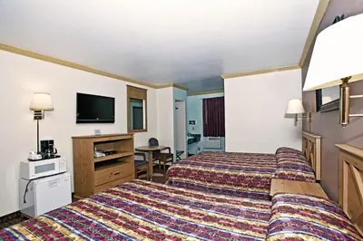 a hotel room with two beds and a flat screen tv at National 9 Inn - Placerville in Placerville