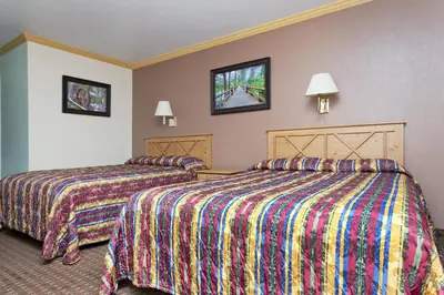 a hotel room with two beds with colorful blankets at National 9 Inn - Placerville in Placerville