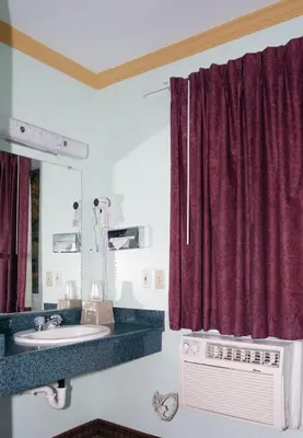 a bathroom with a sink and a mirror at National 9 Inn - Placerville in Placerville