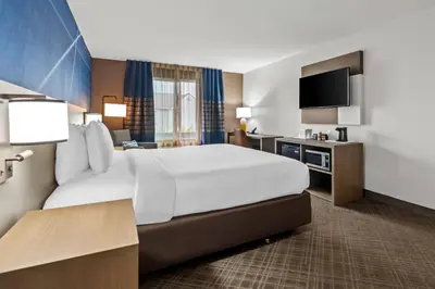 a hotel room with a large bed and a flat screen tv at Comfort Inn South San Jose - Morgan Hill in Morgan Hill