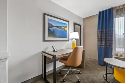a hotel room with a desk and a chair at Comfort Inn South San Jose - Morgan Hill in Morgan Hill