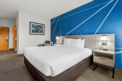 a large white bed in a room with a blue wall at Comfort Inn South San Jose - Morgan Hill in Morgan Hill