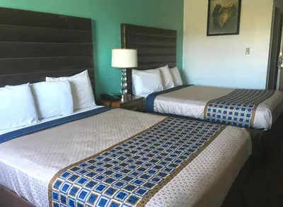 two beds in a hotel room next to each other at Studio 6 Suites Delano, CA in Delano
