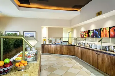 a restaurant with a buffet with fruits and vegetables at Hilton Stockton in Stockton
