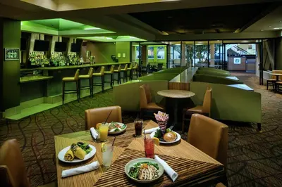 a restaurant with a table with food and a bar at Hilton Stockton in Stockton
