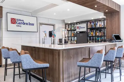 a bar in a restaurant with bar stools at Hilton Garden Inn Gilroy in Gilroy
