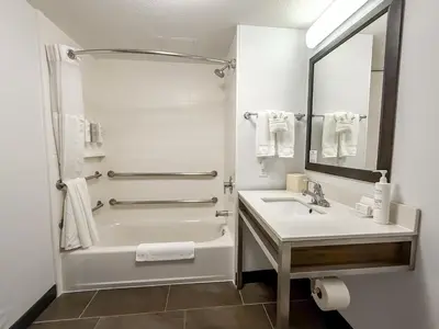 a white bathroom with a tub and a sink at Hilton Garden Inn Gilroy in Gilroy