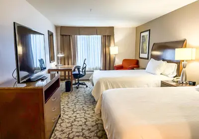 a hotel room with two beds and a flat screen tv at Hilton Garden Inn Gilroy in Gilroy