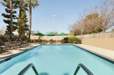 a swimming pool with tables and chairs in a resort at Hilton Garden Inn Gilroy in Gilroy