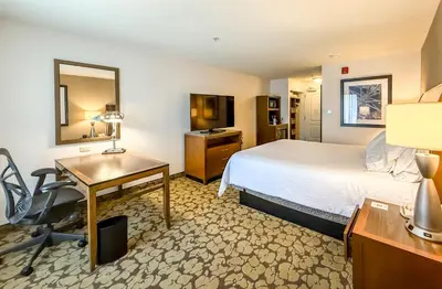 a hotel room with a bed and a desk at Hilton Garden Inn Gilroy in Gilroy