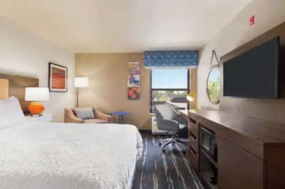 a hotel room with a bed and a flat screen tv at Hampton Inn Sacramento/Rancho Cordova in Rancho Cordova