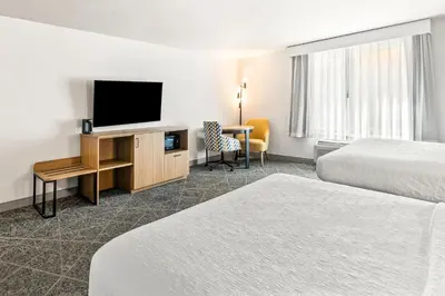 a hotel room with two beds and a flat screen tv at Hampton Inn and Suites Merced in Merced