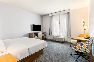 a hotel room with a bed and a desk and a tv at Hampton Inn and Suites Merced in Merced
