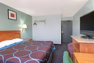 a hotel room with a bed and a flat screen tv at Super 8 by Wyndham Sacramento/Florin Rd in Sacramento