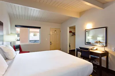 a bedroom with a large white bed and a desk at Days Inn by Wyndham Chowchilla Gateway to Yosemite in Chowchilla